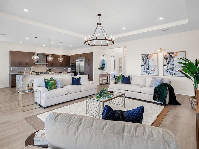 living room featuring a notable chandelier and light wood-type flooring