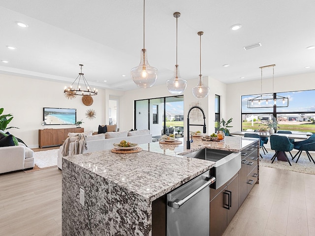 kitchen with a large island, light hardwood / wood-style floors, stainless steel dishwasher, and a notable chandelier