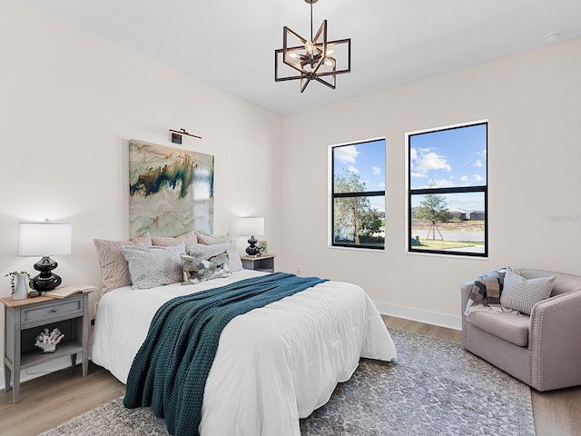 bedroom featuring a notable chandelier and hardwood / wood-style flooring