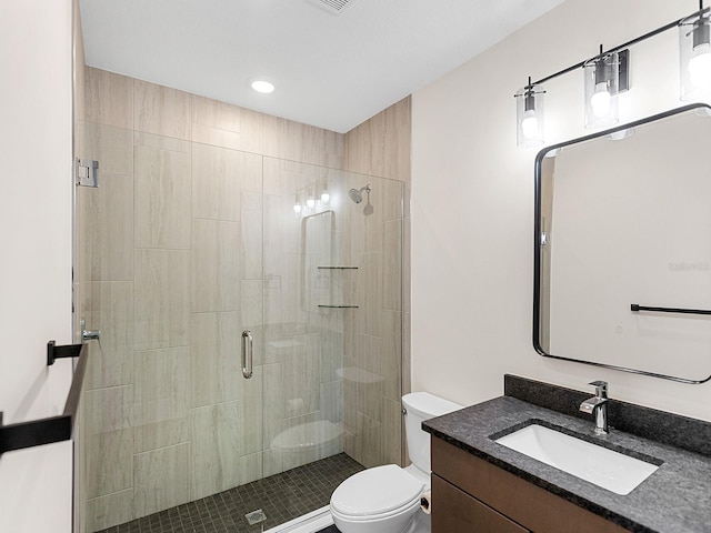 bathroom with vanity, toilet, and a shower with door