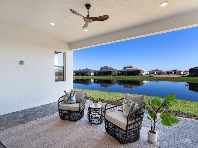 view of patio / terrace featuring ceiling fan and a water view