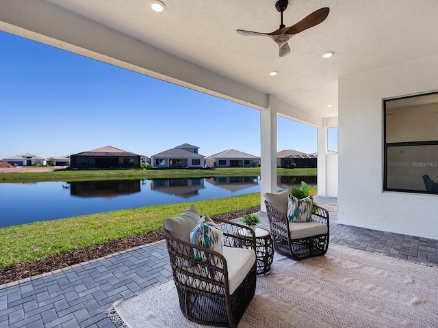 view of patio featuring outdoor lounge area, ceiling fan, and a water view