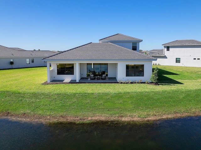 rear view of property with a lawn and a patio