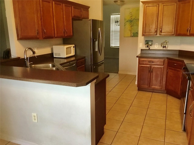 kitchen featuring dishwasher, light tile patterned flooring, kitchen peninsula, and sink