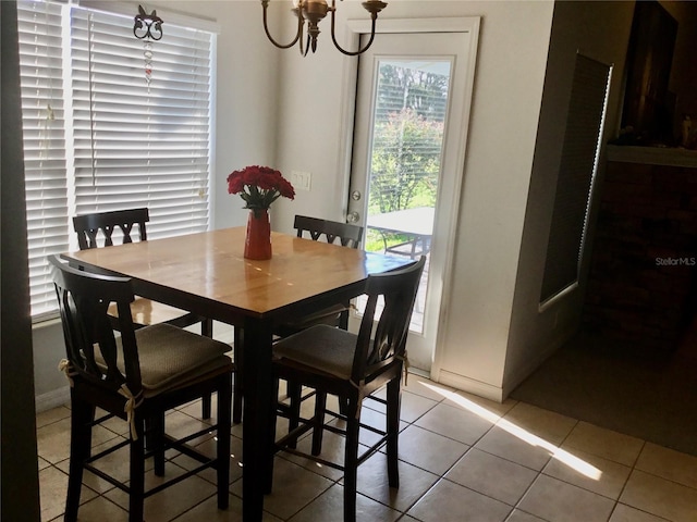 tiled dining room with a chandelier