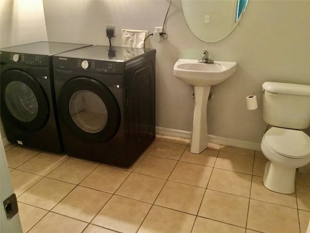 washroom featuring sink, light tile patterned floors, and washer and dryer