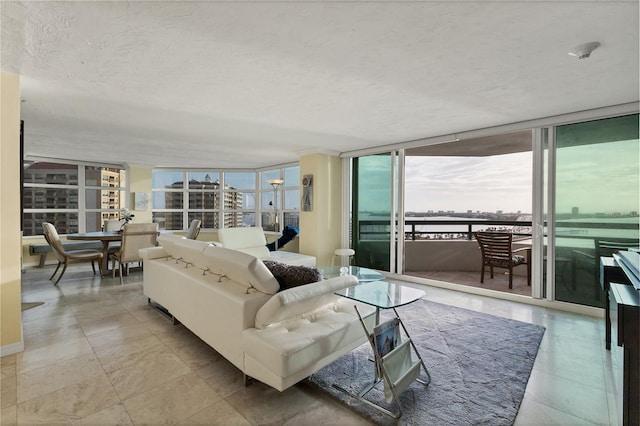 living room with a textured ceiling and floor to ceiling windows