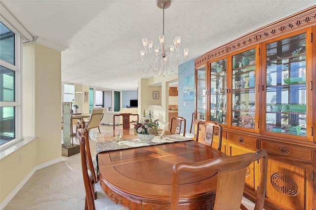 dining space with a textured ceiling and an inviting chandelier