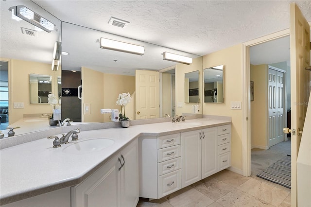 bathroom featuring tile patterned floors, vanity, and a textured ceiling