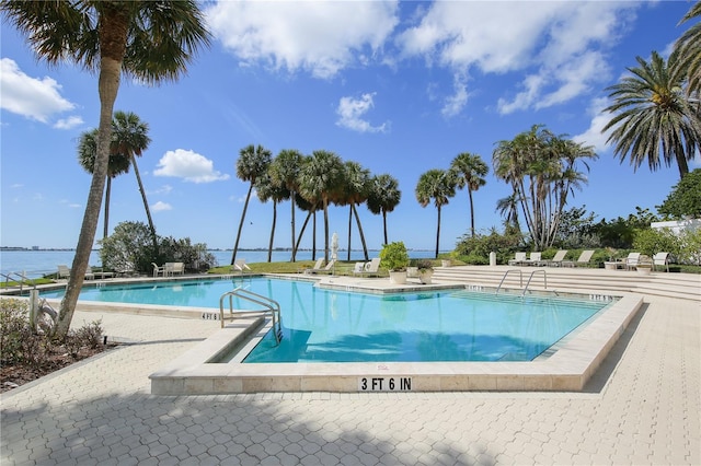 view of pool with a patio area and a water view