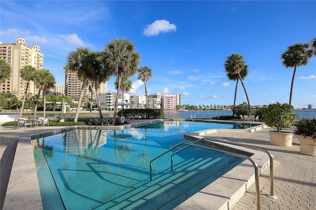 view of swimming pool with a patio area and a water view