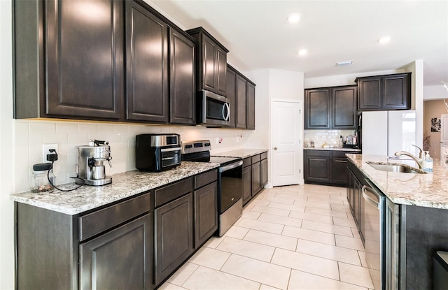 kitchen with decorative backsplash, dark brown cabinets, stainless steel appliances, and sink