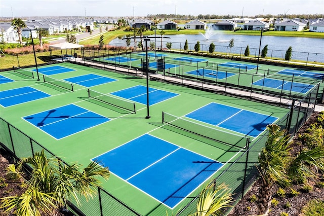 view of tennis court with a water view