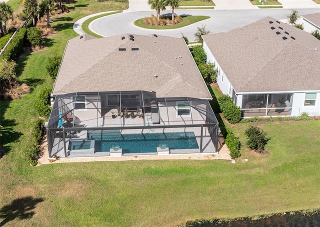 exterior space featuring an outdoor pool, roof with shingles, glass enclosure, and a lawn