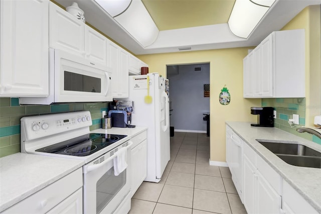 kitchen featuring sink, tasteful backsplash, light tile patterned flooring, white cabinetry, and white appliances