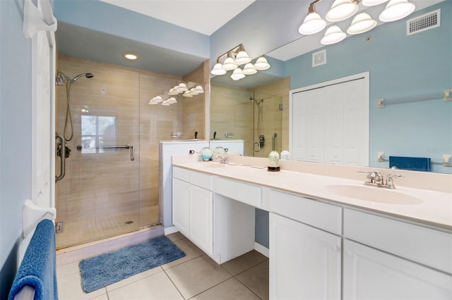 bathroom featuring tile patterned flooring, vanity, and a shower with door