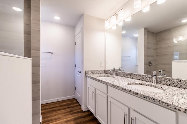 bathroom featuring vanity, hardwood / wood-style floors, and a tile shower