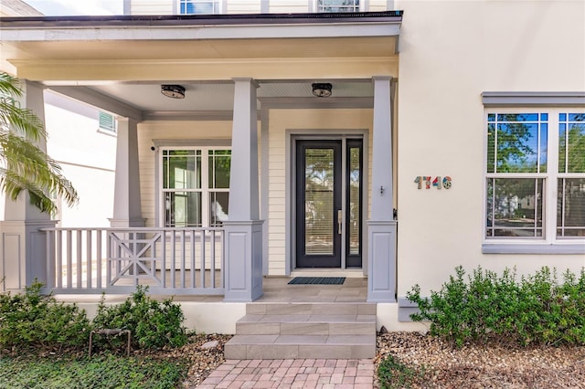 view of exterior entry with a porch