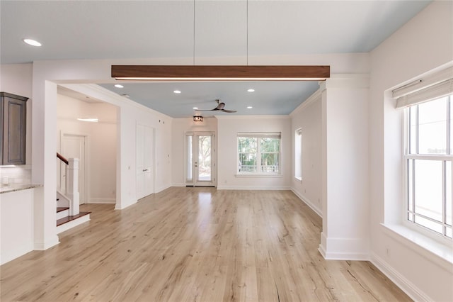 unfurnished living room featuring light wood-type flooring, ceiling fan, and crown molding