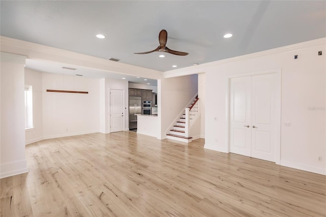 unfurnished living room featuring ceiling fan, ornamental molding, and light wood-type flooring