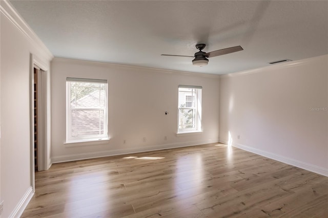 empty room featuring plenty of natural light, light hardwood / wood-style floors, and ceiling fan