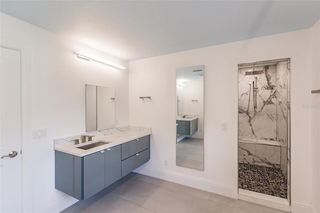 bathroom with tiled shower, a textured ceiling, vanity, and tile patterned flooring