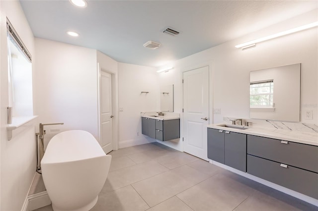 bathroom featuring tile patterned flooring, vanity, and a bath