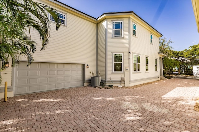 exterior space with central AC and a garage