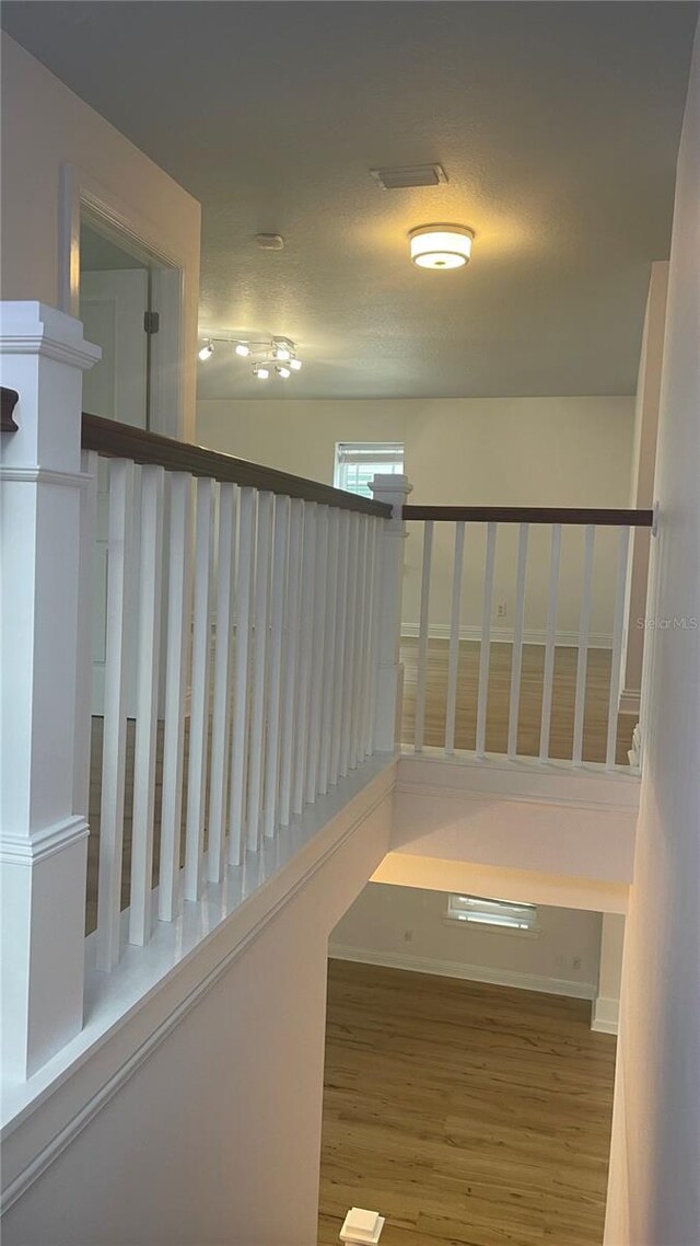 stairs with a textured ceiling and hardwood / wood-style flooring