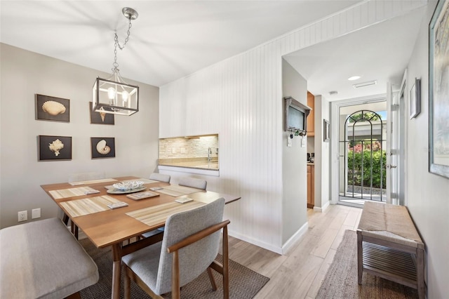 dining space with a chandelier and light hardwood / wood-style floors