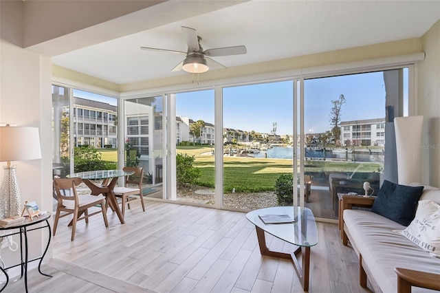 sunroom / solarium featuring a water view, a wealth of natural light, and ceiling fan