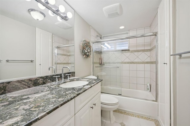 full bathroom featuring tile patterned floors, vanity, toilet, and bath / shower combo with glass door