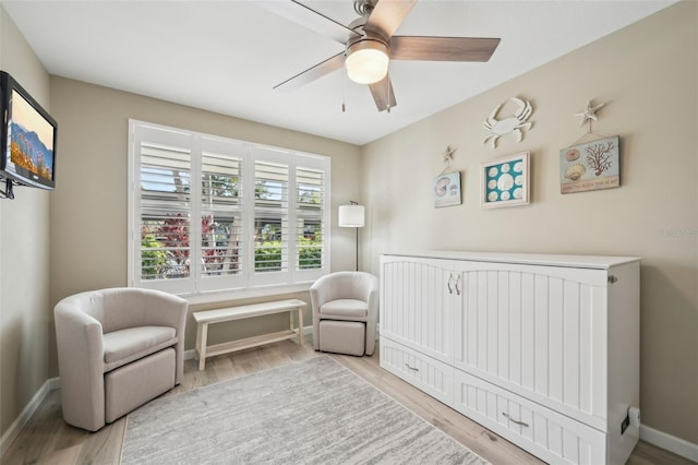 bedroom featuring a crib, light hardwood / wood-style flooring, and ceiling fan