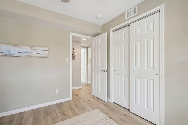 unfurnished bedroom featuring light wood-type flooring and a closet