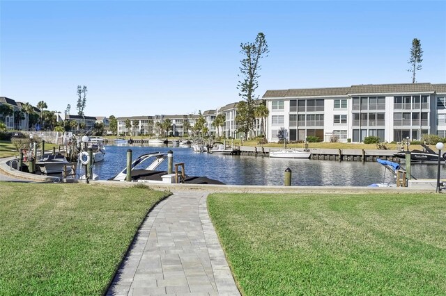 view of dock featuring a lawn and a water view