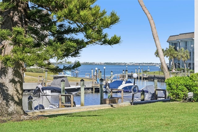 view of dock featuring a lawn and a water view