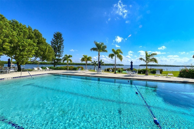 view of pool with a water view and a patio