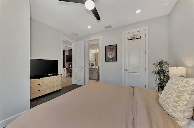 bedroom with dark colored carpet, ensuite bathroom, and ceiling fan