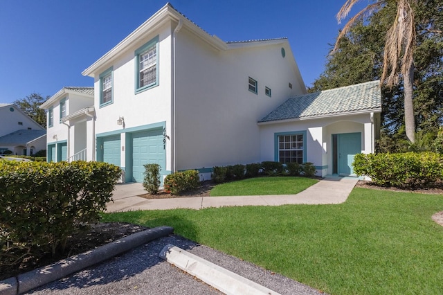 mediterranean / spanish-style home with a front yard and a garage