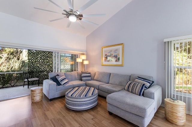 living room with hardwood / wood-style flooring, ceiling fan, and high vaulted ceiling