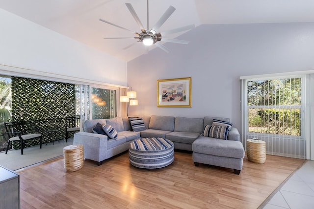 living room featuring light hardwood / wood-style floors, high vaulted ceiling, and ceiling fan