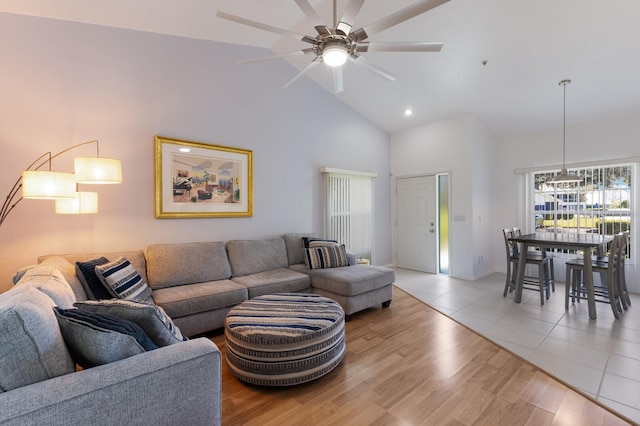 living room with ceiling fan, light hardwood / wood-style flooring, and high vaulted ceiling