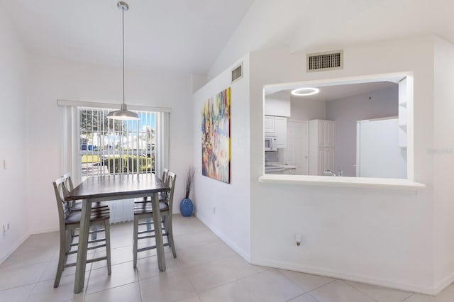 dining room featuring light tile patterned flooring and vaulted ceiling