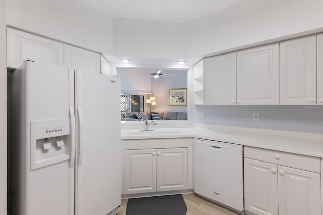 kitchen featuring white appliances, sink, light hardwood / wood-style flooring, ceiling fan, and white cabinetry