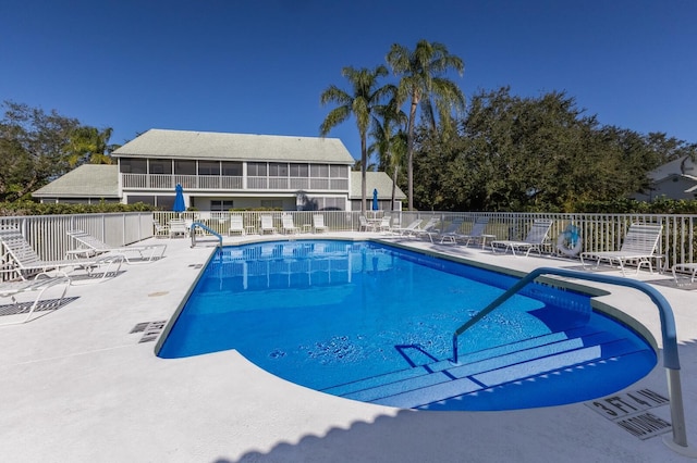 view of swimming pool with a patio and a sunroom