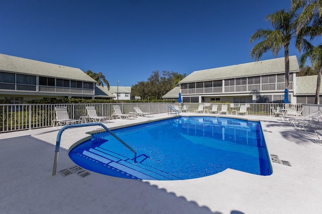 view of swimming pool featuring a patio area and a sunroom