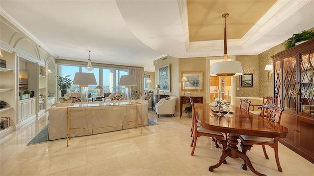 dining room with a raised ceiling and ornamental molding