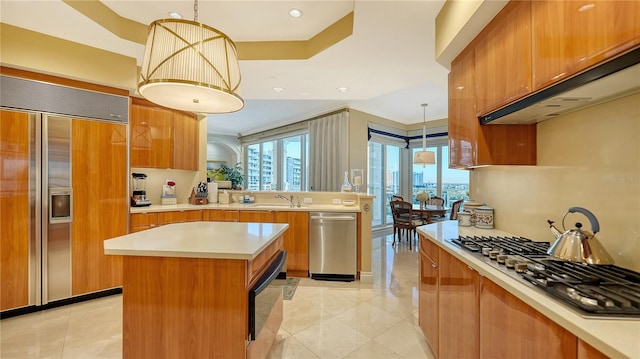 kitchen with decorative light fixtures, a kitchen island, ornamental molding, and stainless steel appliances