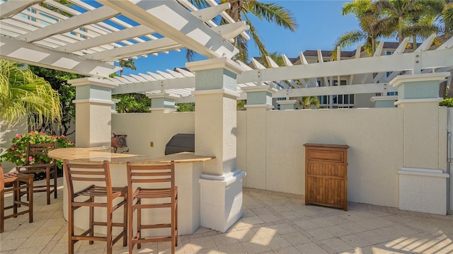 view of patio featuring a bar and a pergola