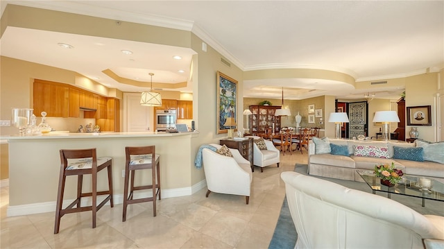 living room featuring a raised ceiling, ornamental molding, light tile patterned floors, recessed lighting, and baseboards
